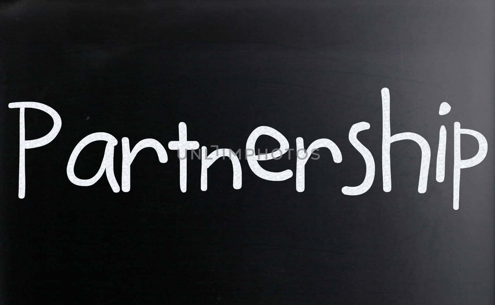 The word "Partnership" handwritten with white chalk on a blackboard