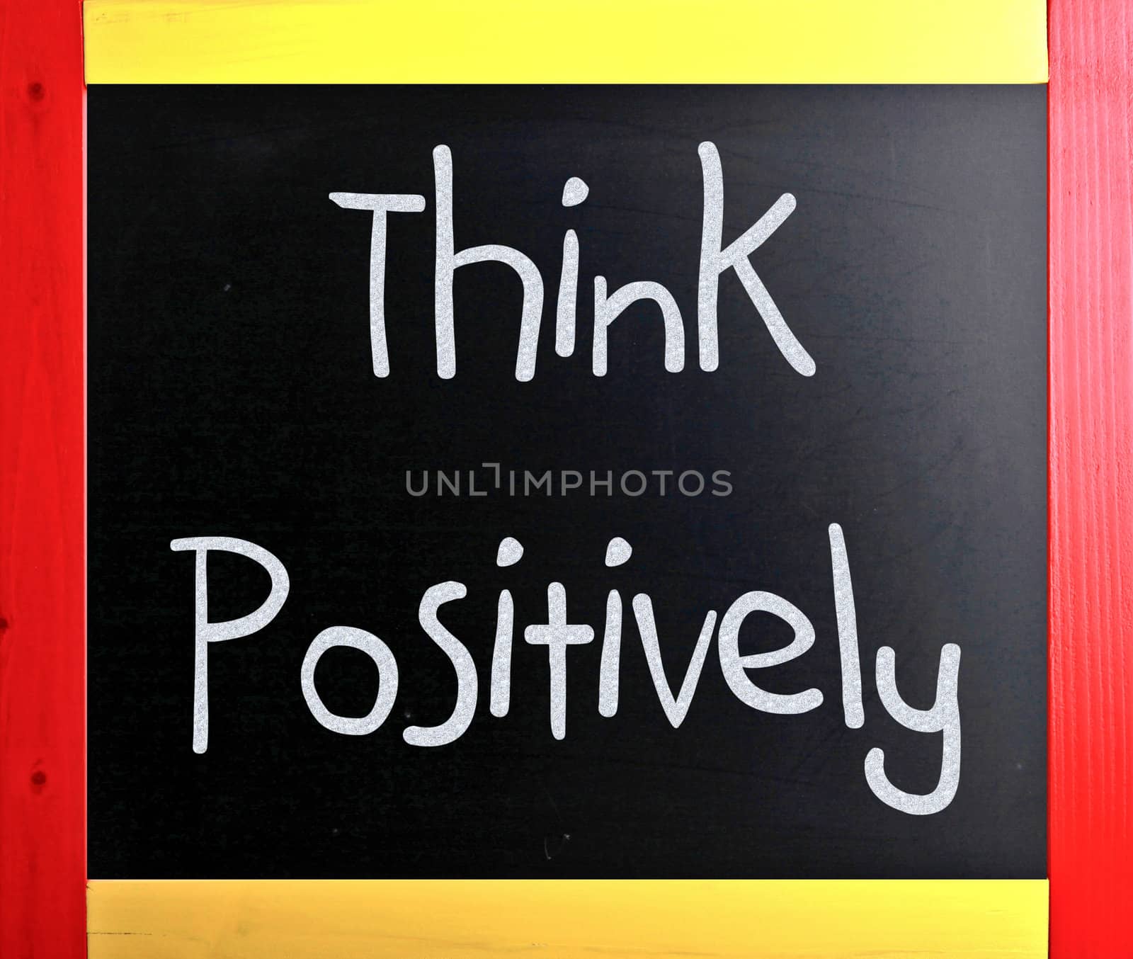 "Think Positively" handwritten with white chalk on a blackboard