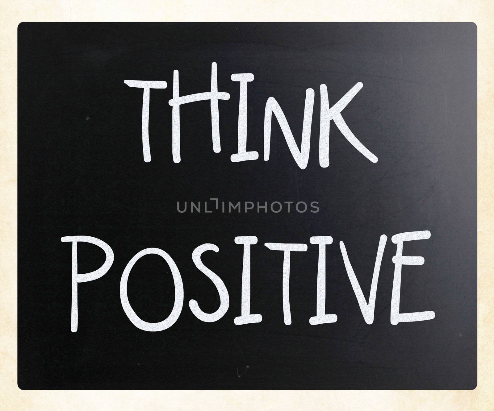 "Think positive" handwritten with white chalk on a blackboard
