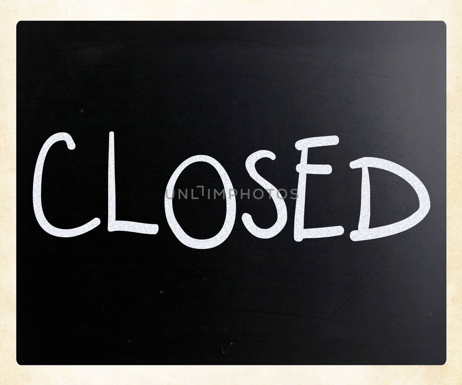 The word "Closed" handwritten with white chalk on a blackboard