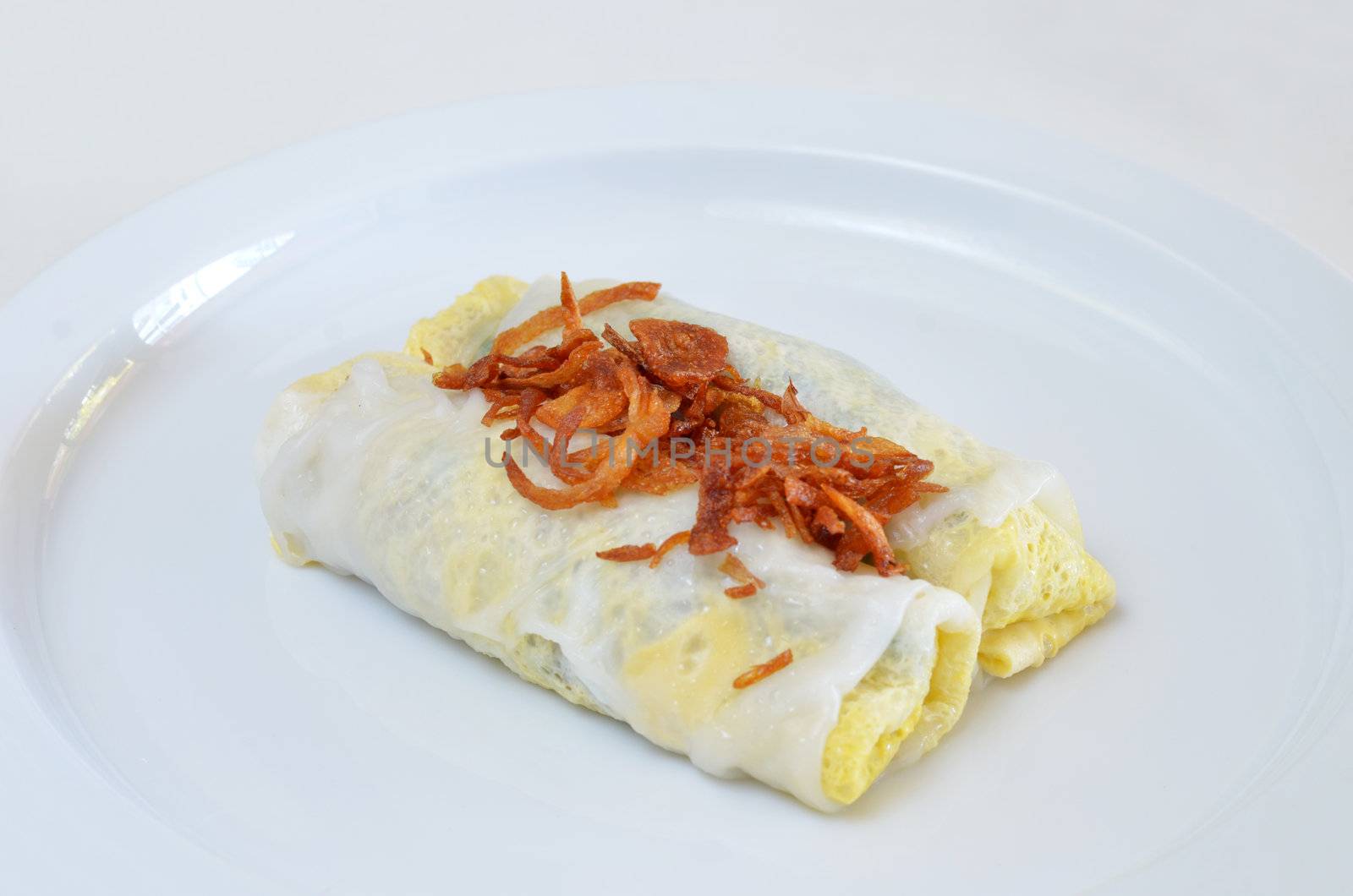 Vietnamese rice noodle rolls with a filling of pork sliced and egg ,  fried onion on white dish