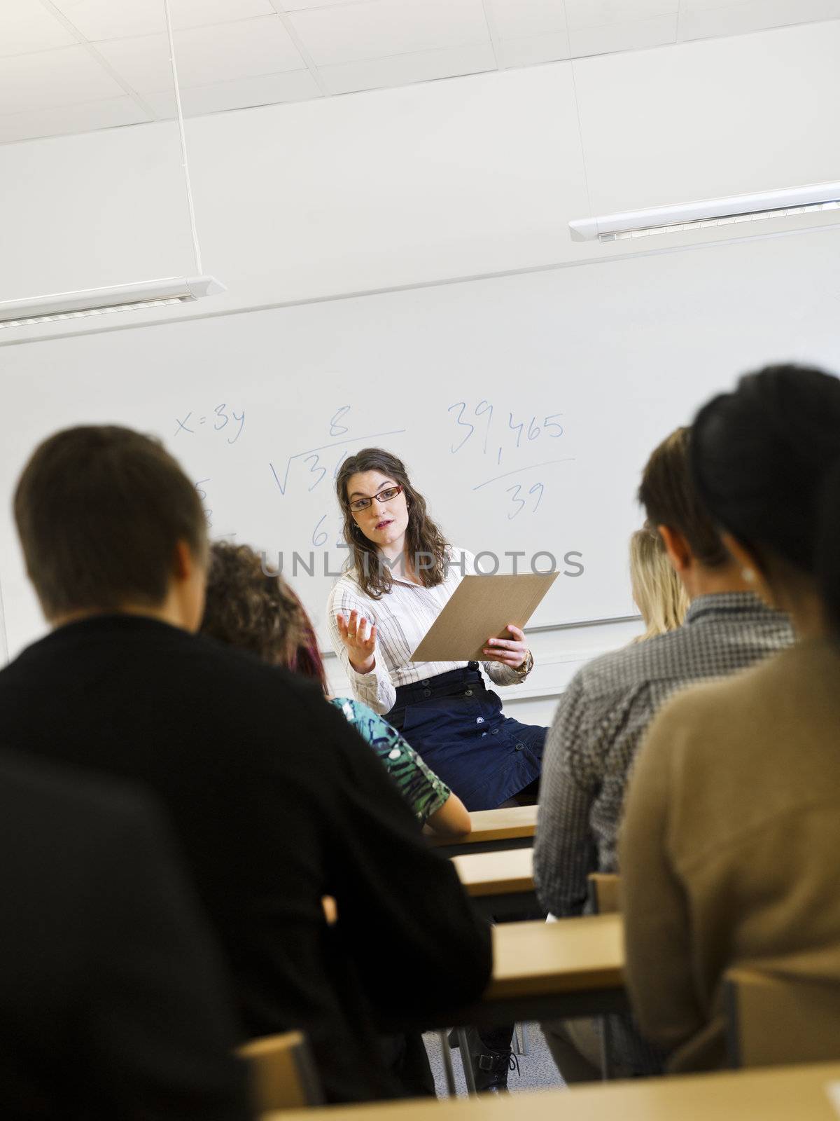 Schoolteacher in front of pupils in the classroom