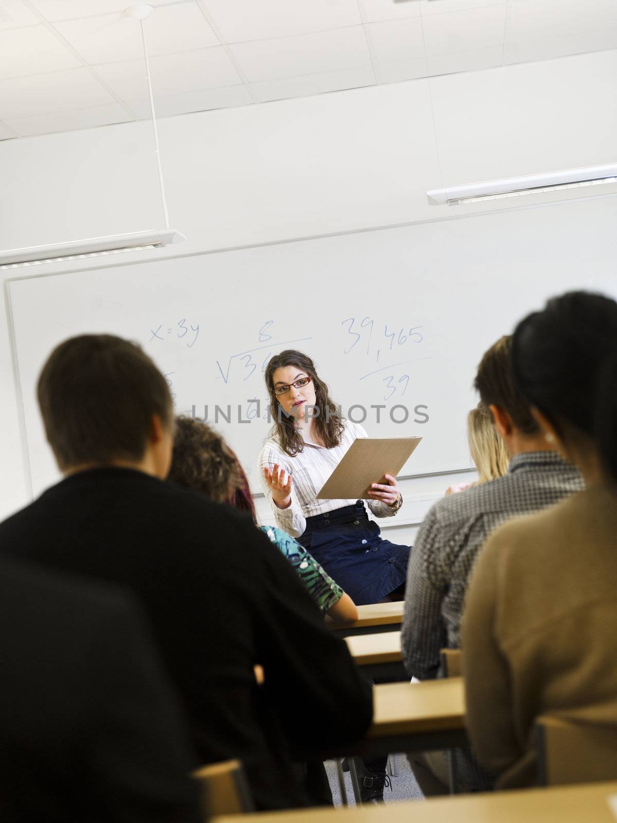 Schoolteacher in front of pupils in the classroom