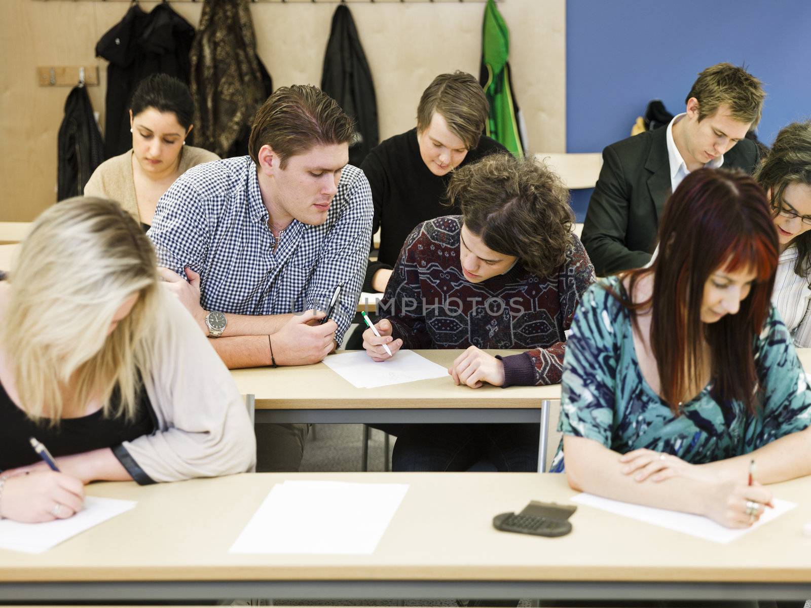 Large group of young adults studying in a classroom