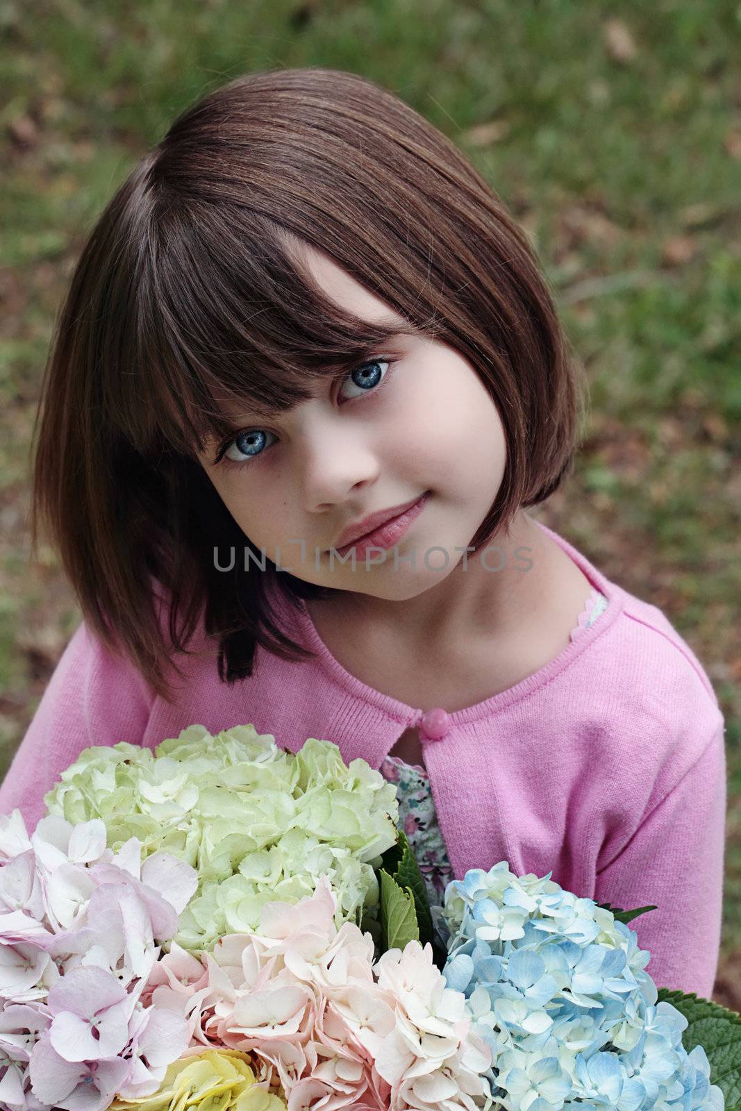 Beautiful little girl witha  bunch of pastel colored Hydrangeas for her mother on Mother's Day.