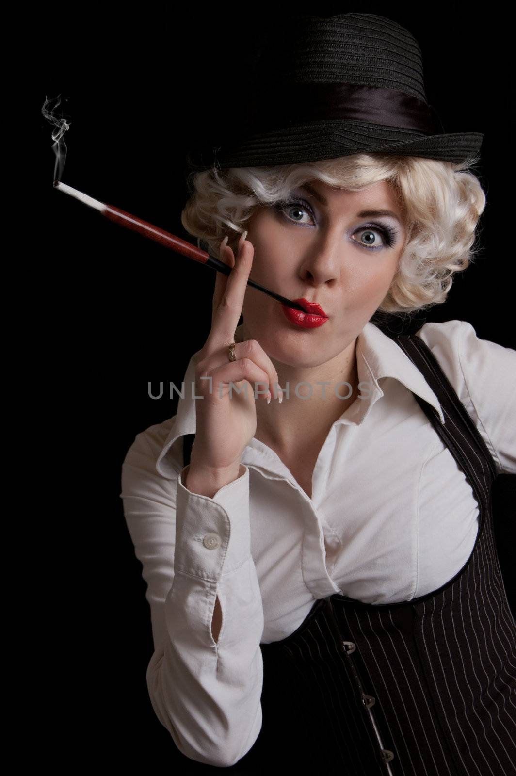 Retro-styled woman in hat with cigarette over black