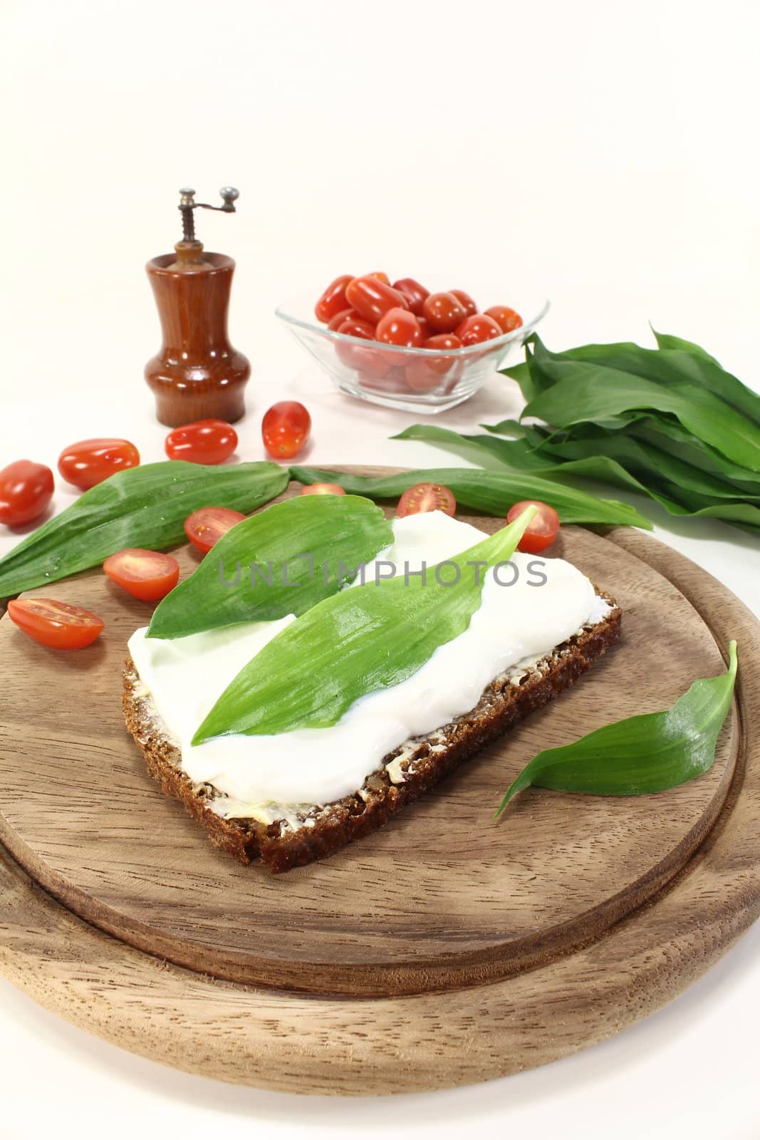 Slice of bread with cottage cheese, ramson and chopped tomatoes