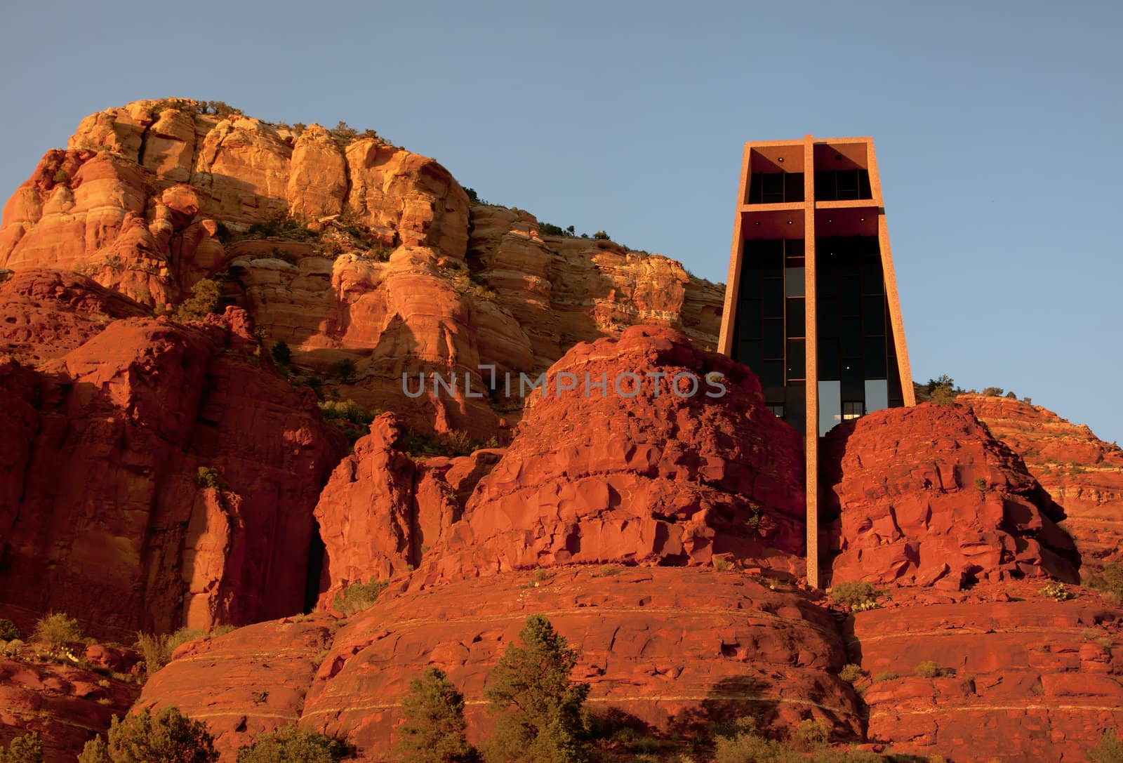 Sunset colors the red rocks even redder around the iconic Christ by Claudine