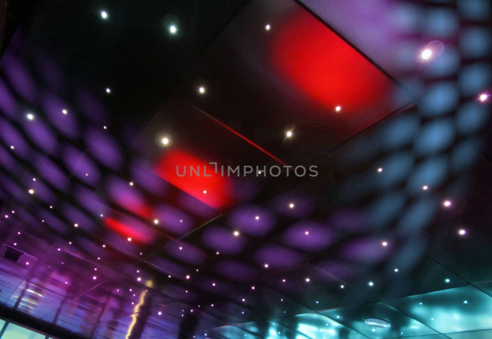 Colorful disco light spots in reflective nightclub ceiling