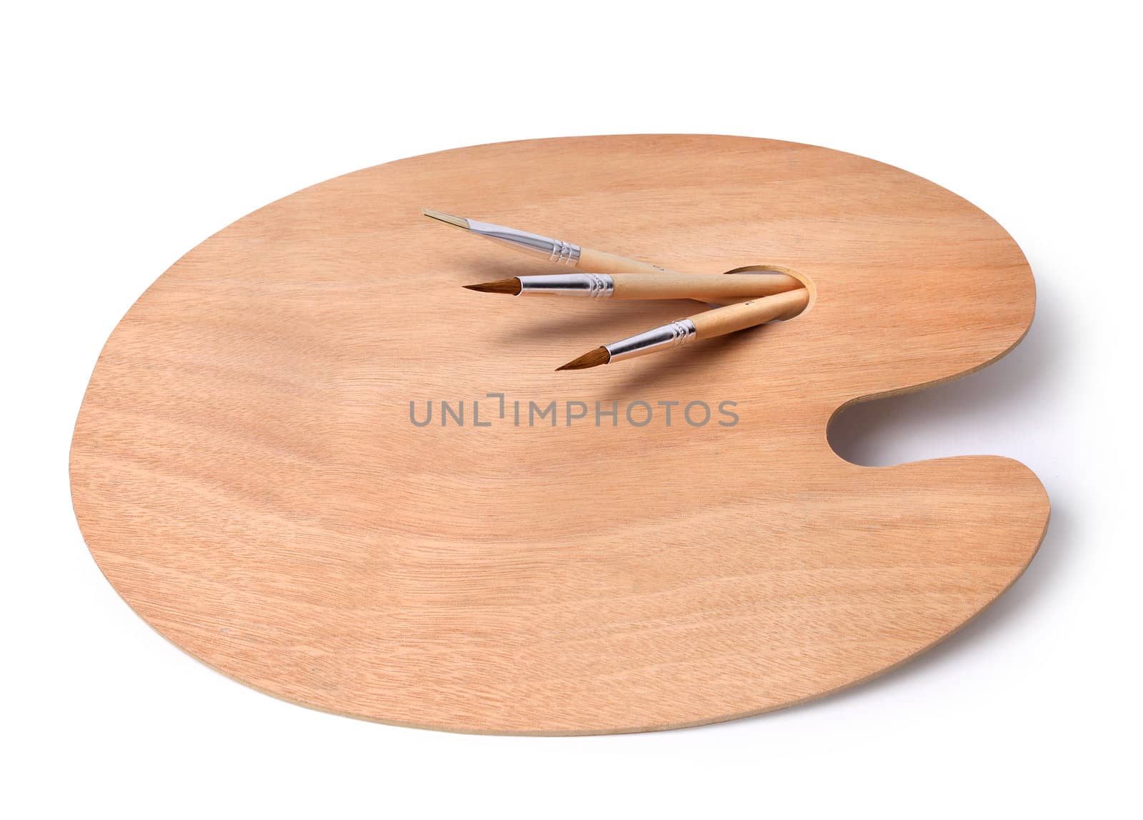 Empty wooden artist palette with paint brushes isolated on white