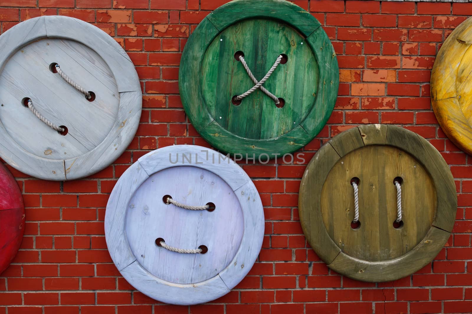 Wooden buttons at the red brick wall