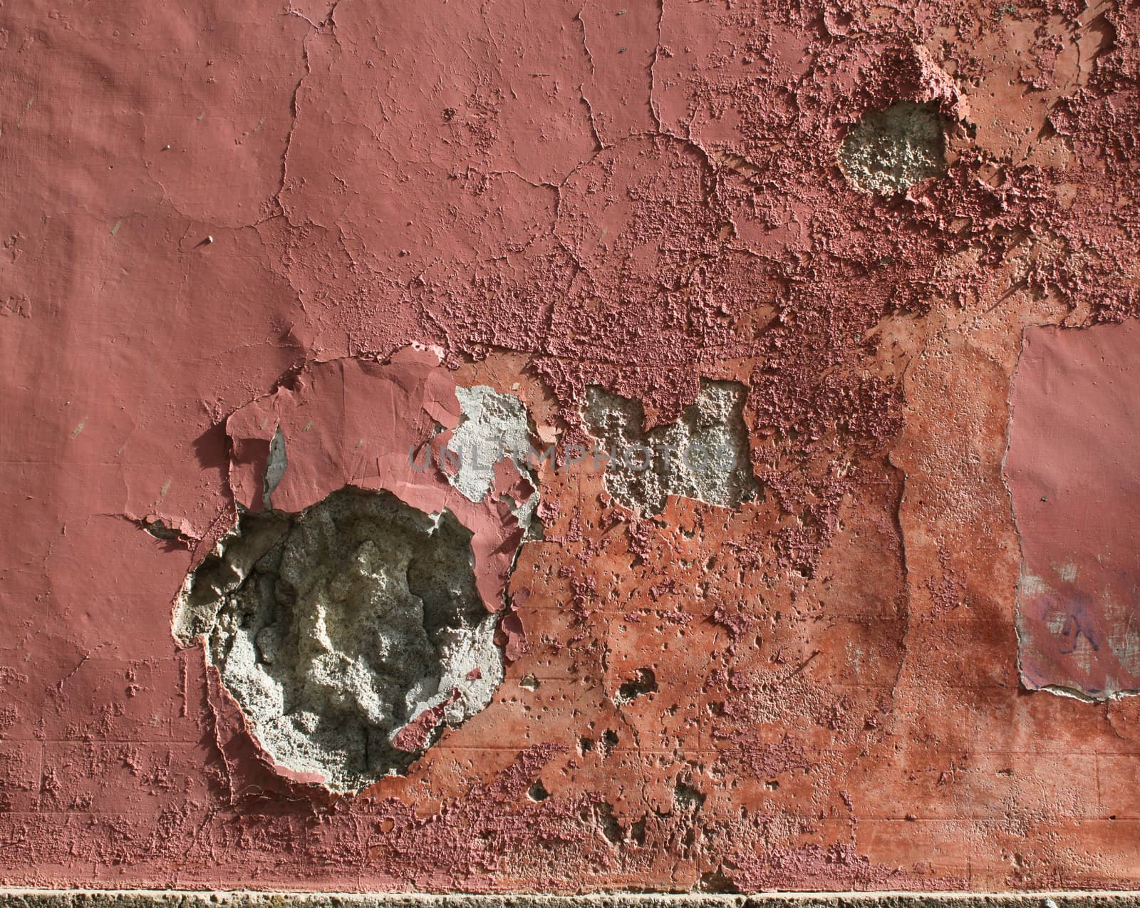 Grungy plaster stone wall with holes and scratches, paint peeling