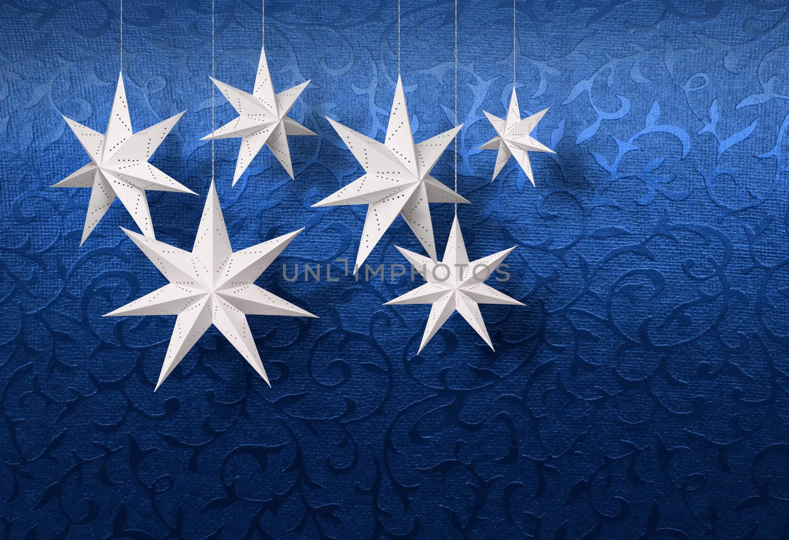 White paper stars on blue Christmas brocade pattern background