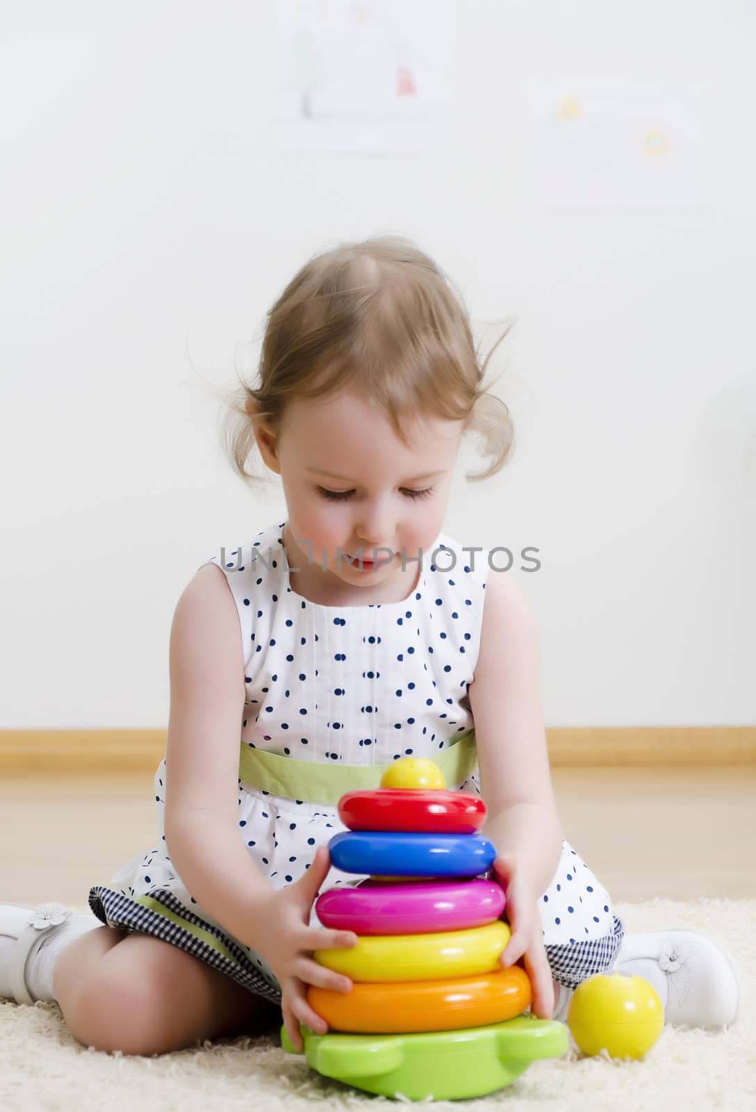 Little girl playing in a pyramid toy