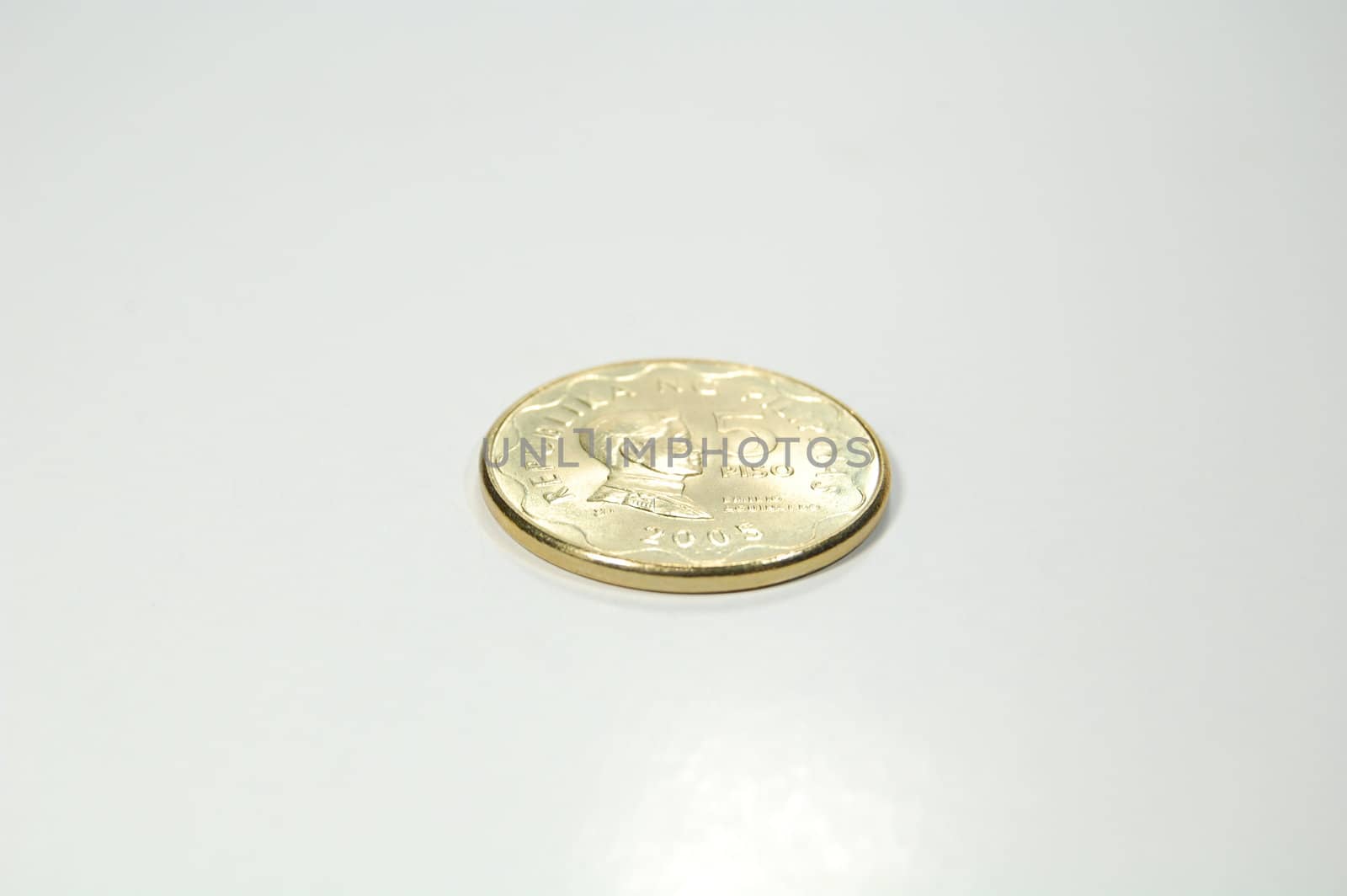 A shiny golden 5-peso coin