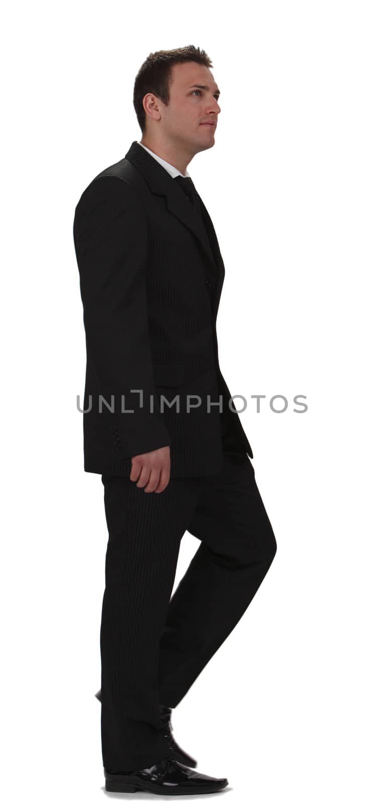 Image of a young businessman walking, isolated against a white background.