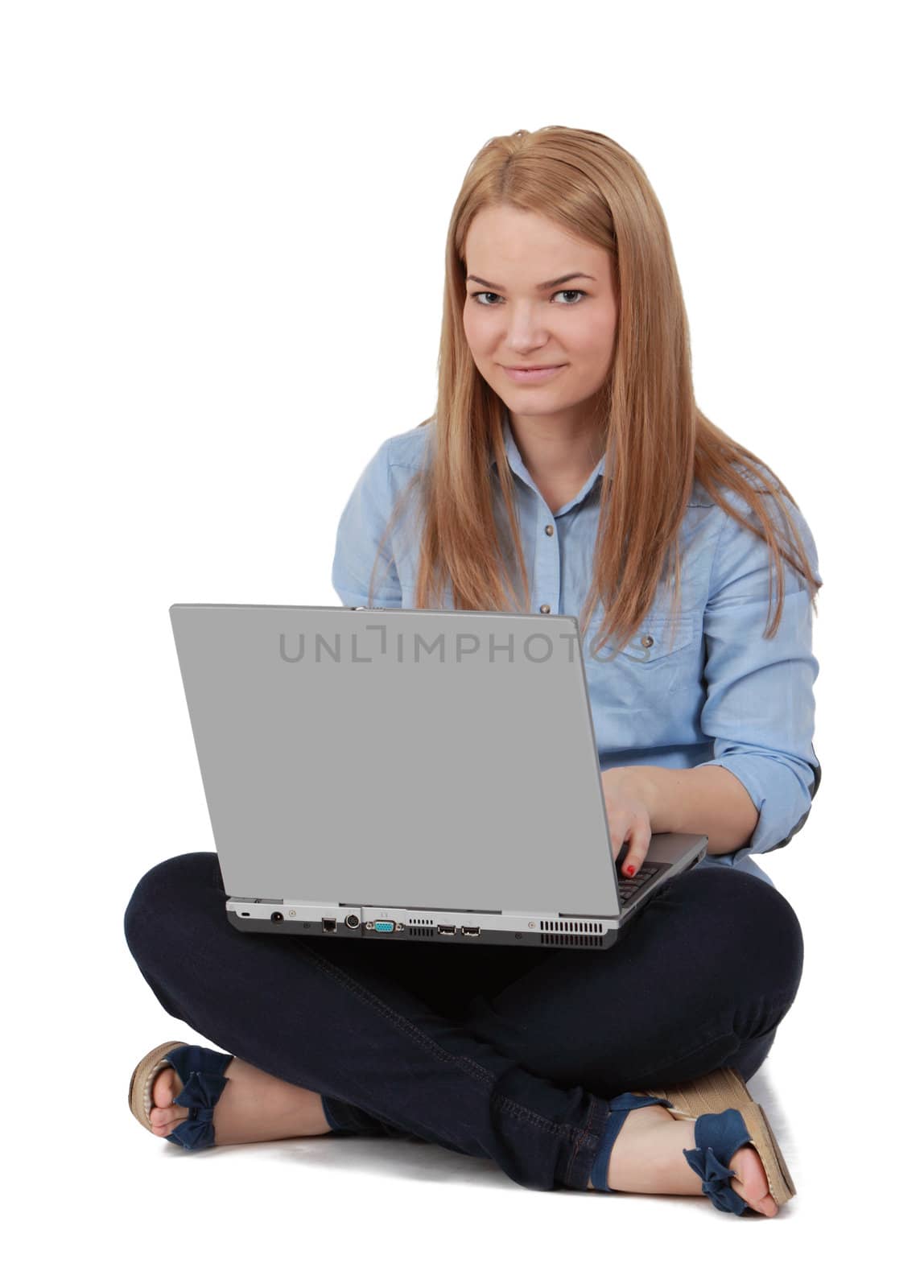 Image of a young blonde woman sitting on a white surface with a laptop in her lap.