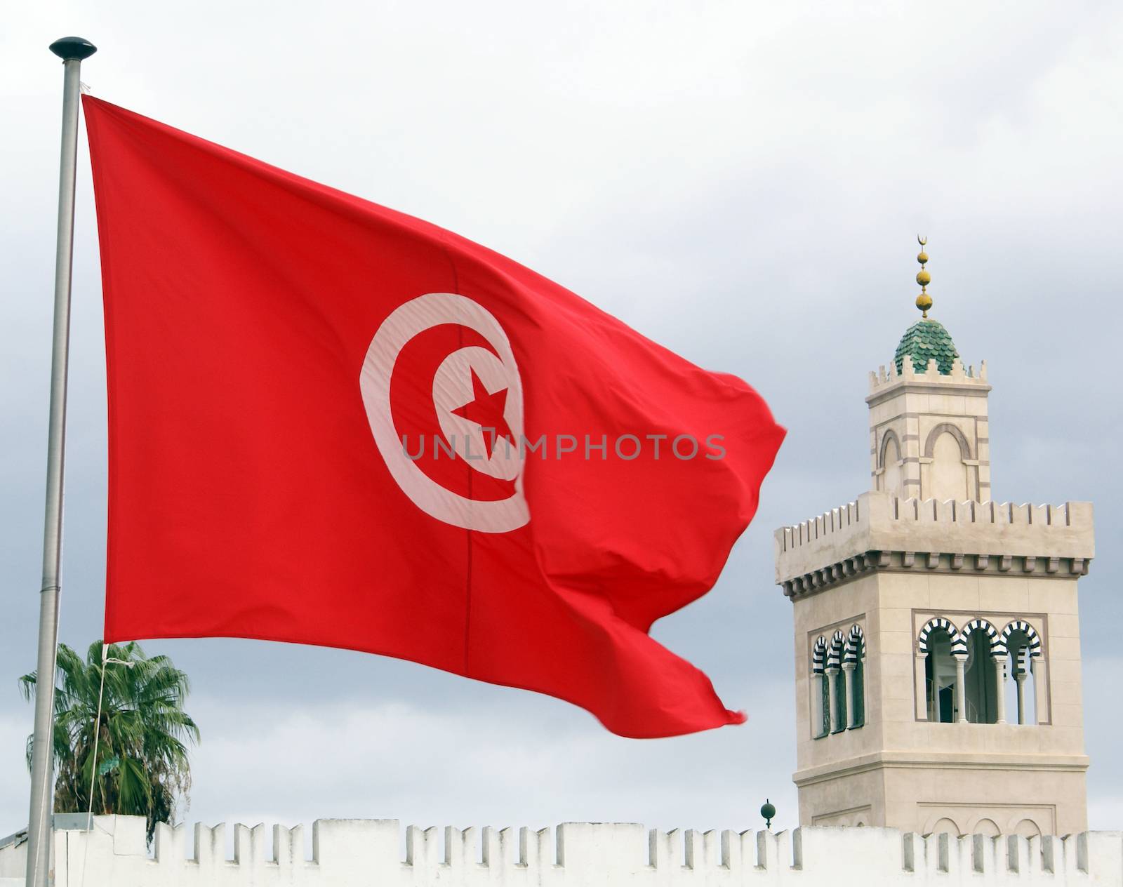 Red flag, clouds and minaret in Tunisia               