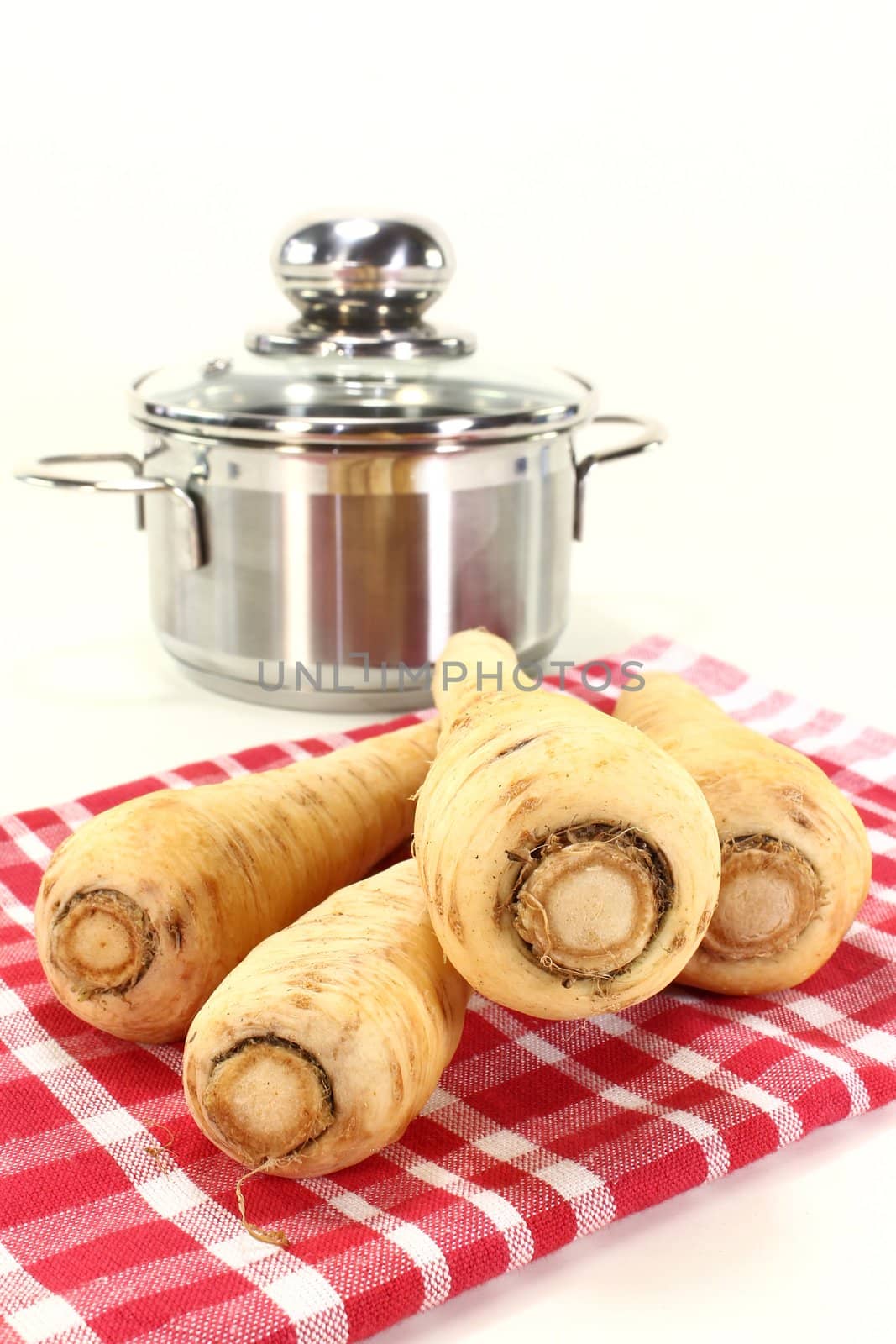 four parsnips on a red dish towel