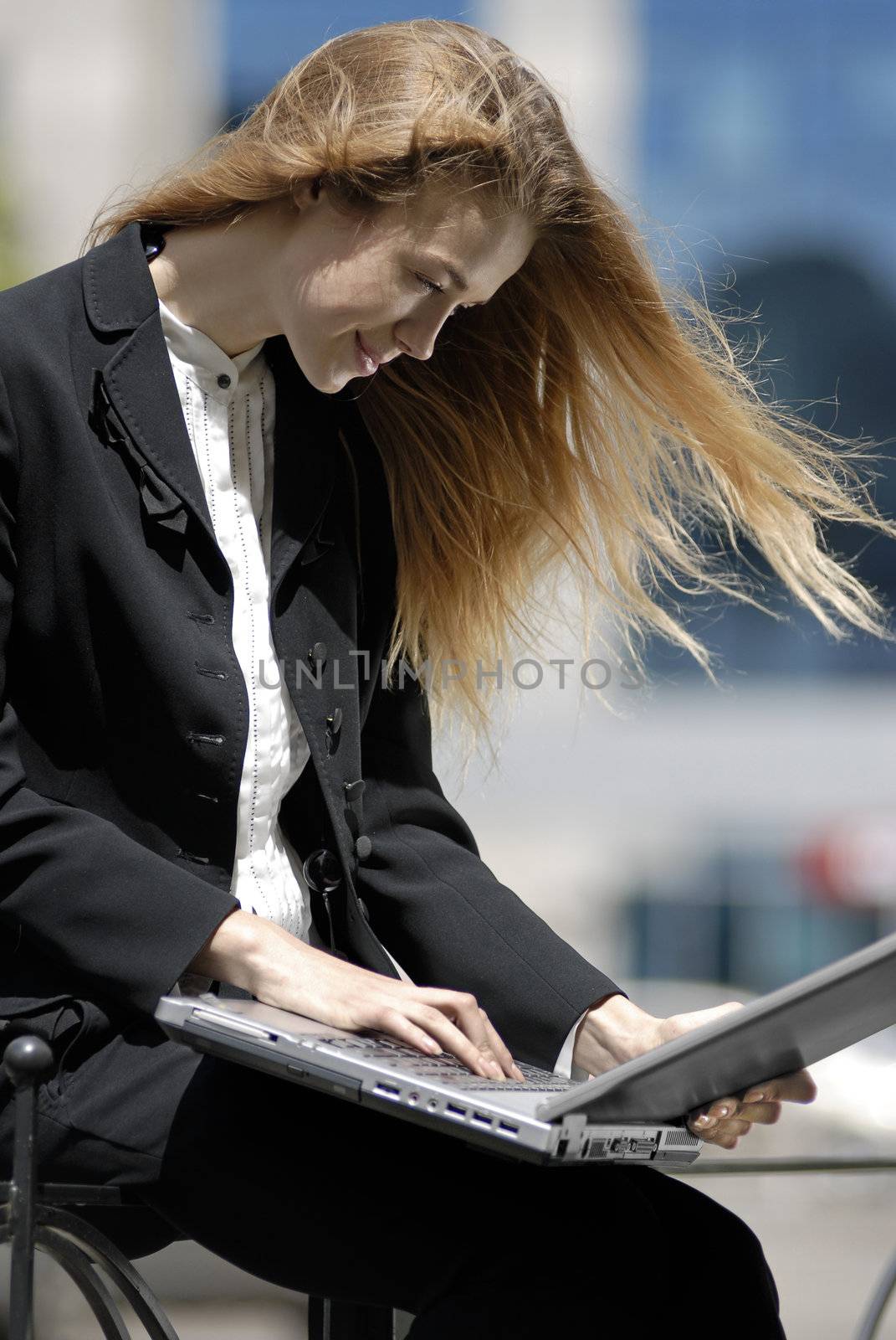 happy undergraduate with laptop computer in the city