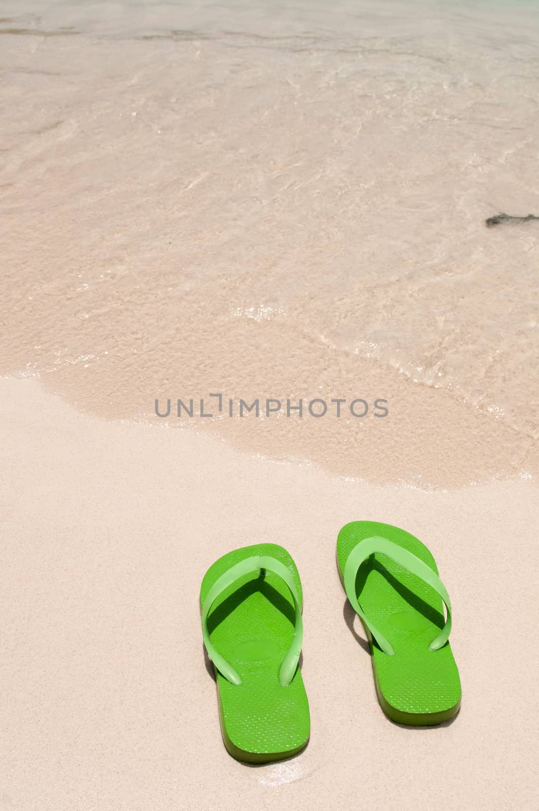 green flip flops on the beach (copy-space available)