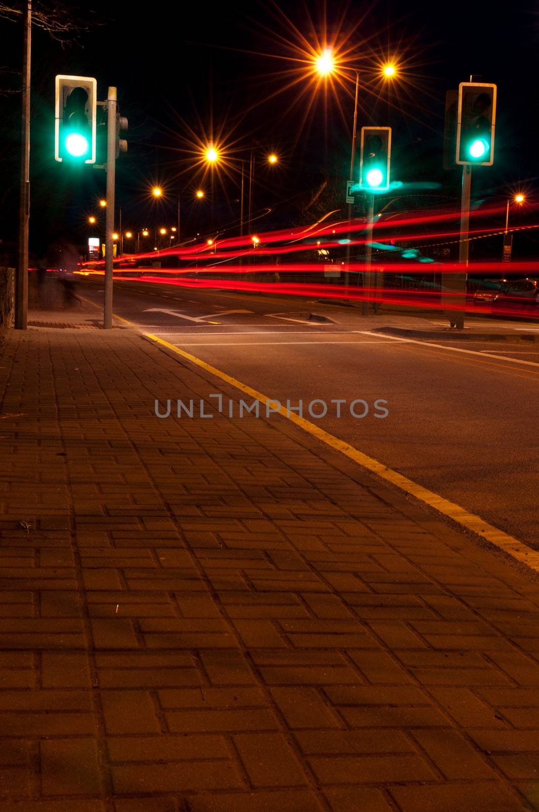 night traffic on a urban road with tail lights (green traffic lights scene, long exposure)