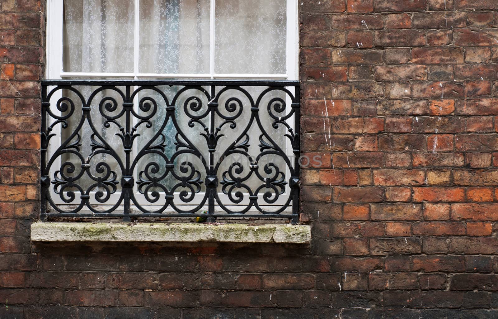 british window with gorgeous balcony and brick wall (available copy-space at the right)