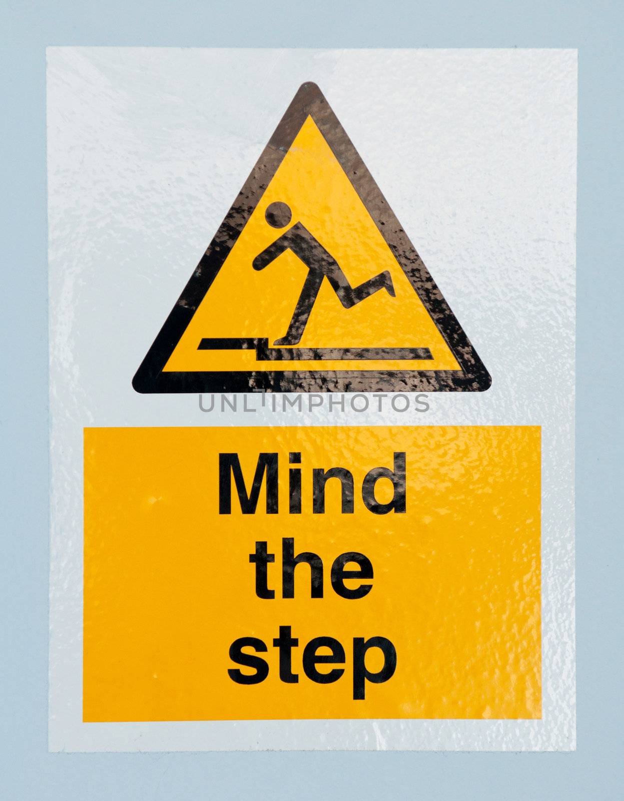 mind the step caution sign on a blue wall background