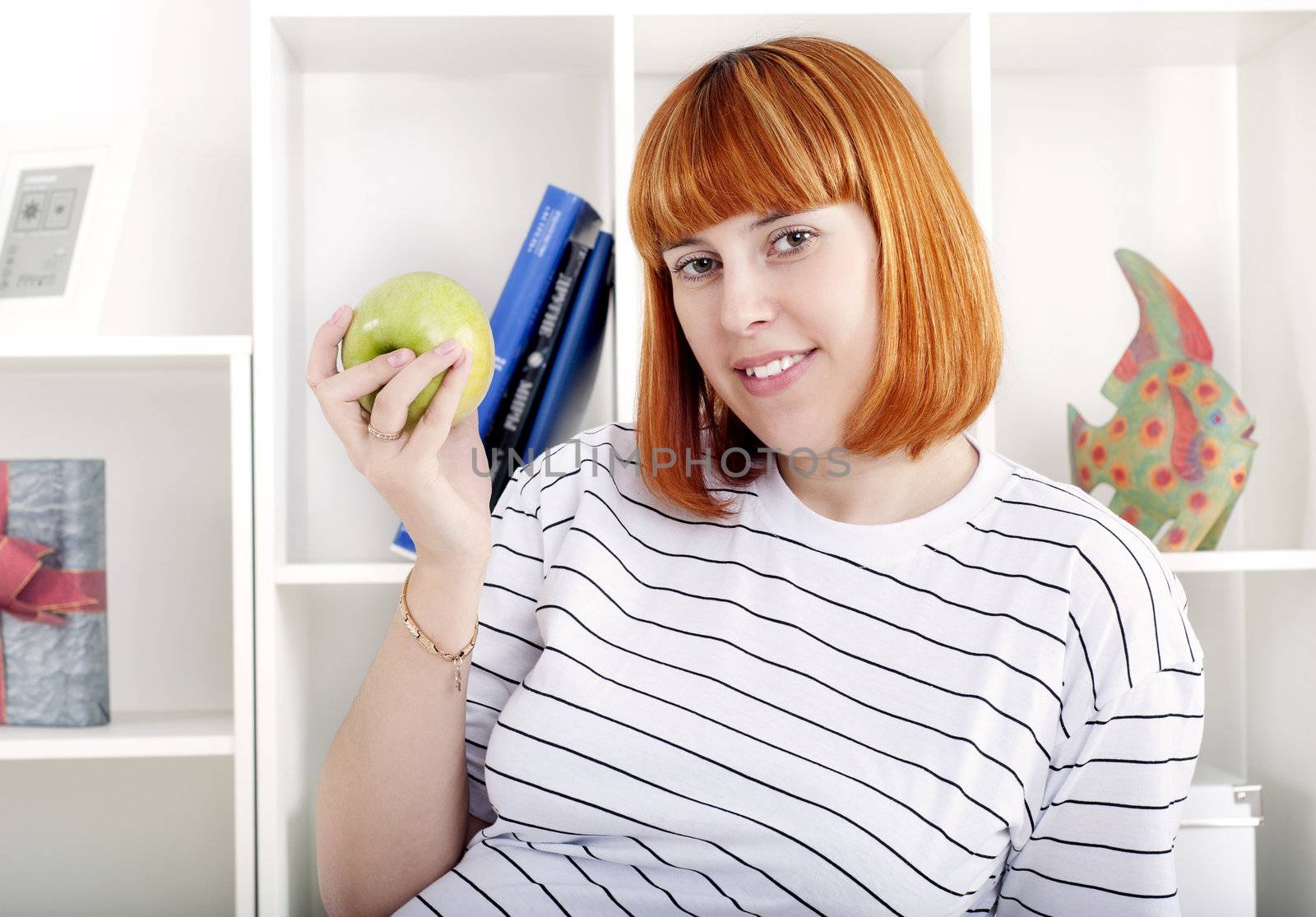 portrait of a beautiful woman, at home, holding an apple in her hand