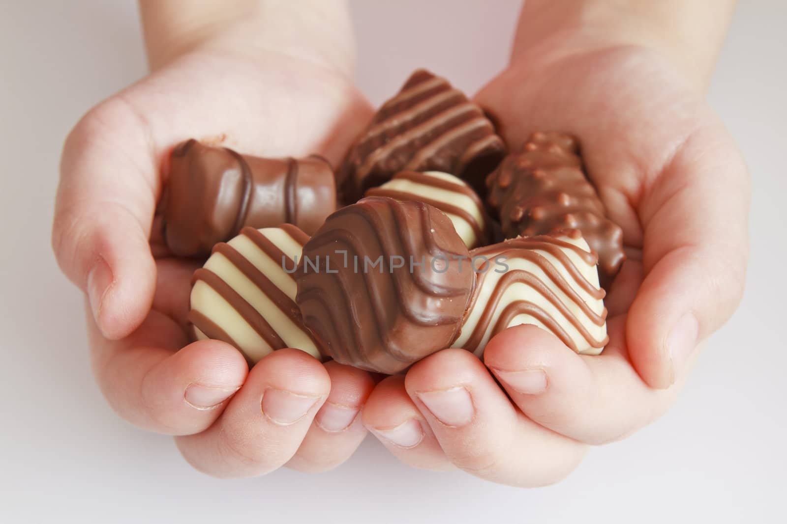 Beautiful chocolate candy in palms.