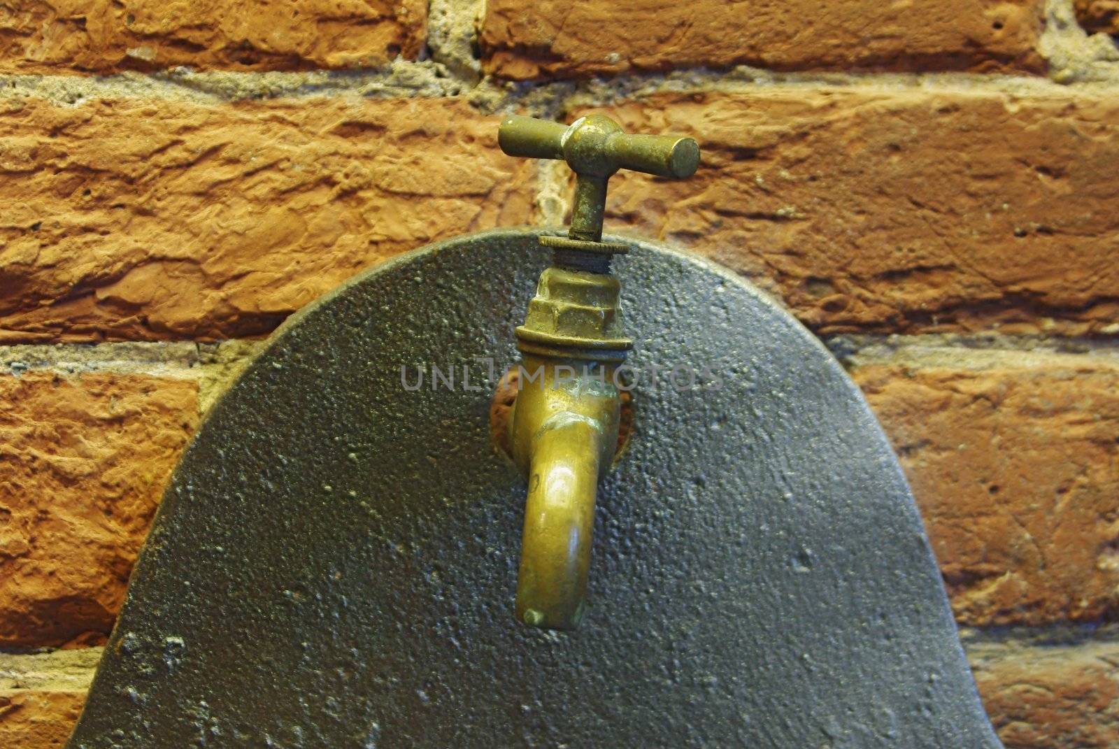 Close up of old water tap over brick wall