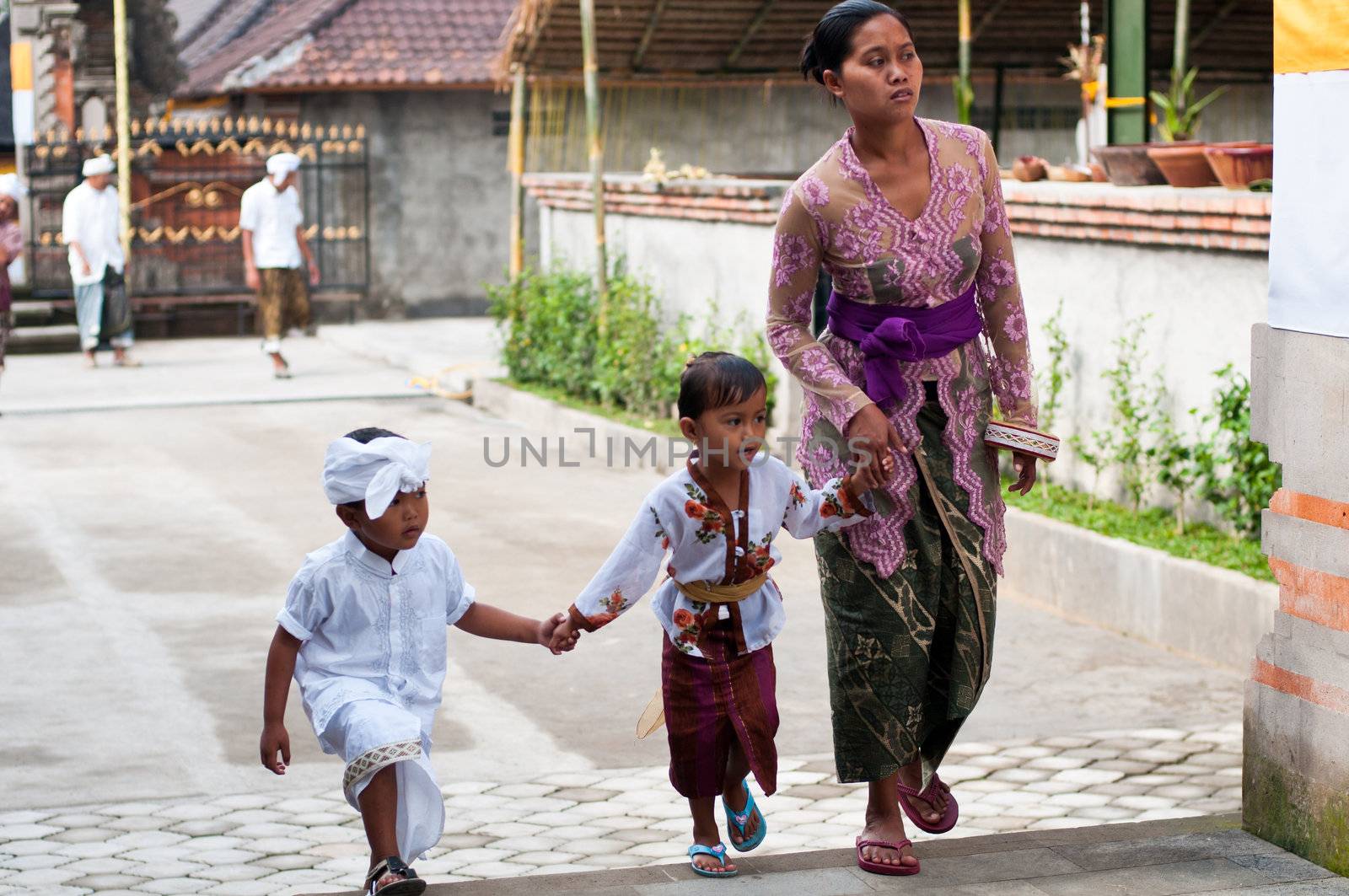 Tirta Empul, Bali, Indonesia - October 11, 2011: woman with here children walking to Tirta Empul Temple to give offerings to the spirits
