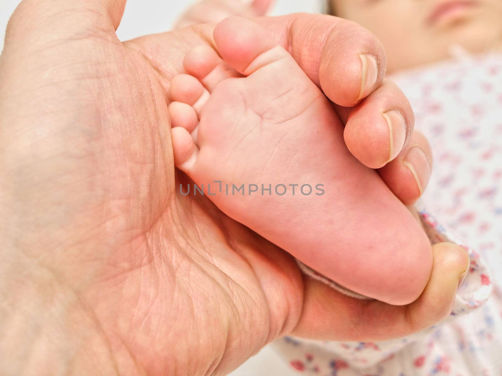 Parent holding an infants foot by Arvebettum