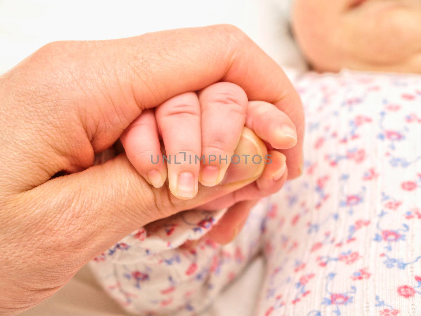 Parent holding an infants hand by Arvebettum