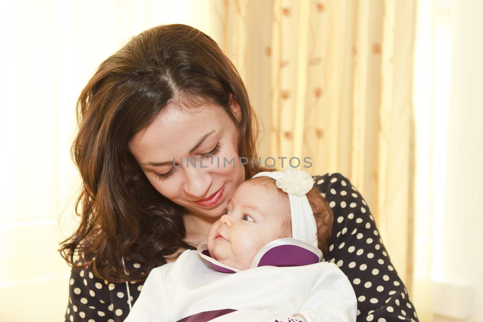 Loving moment of tenderness between a mother and her two moths old baby