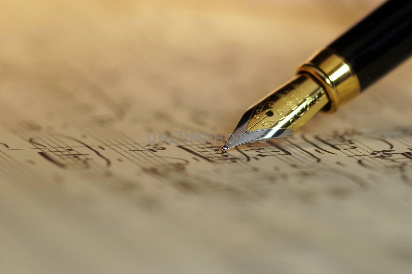 Selective focus of a fountain pen over an old sheet music