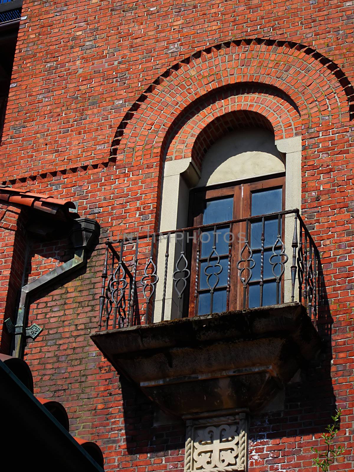 A photograph of a balcony and window detailing their beautiful architectural design.