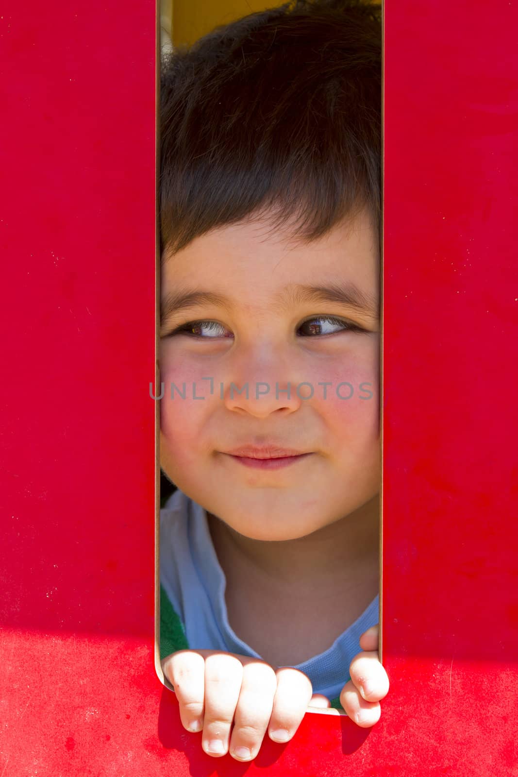 Child playing in red park, smilling, little baby