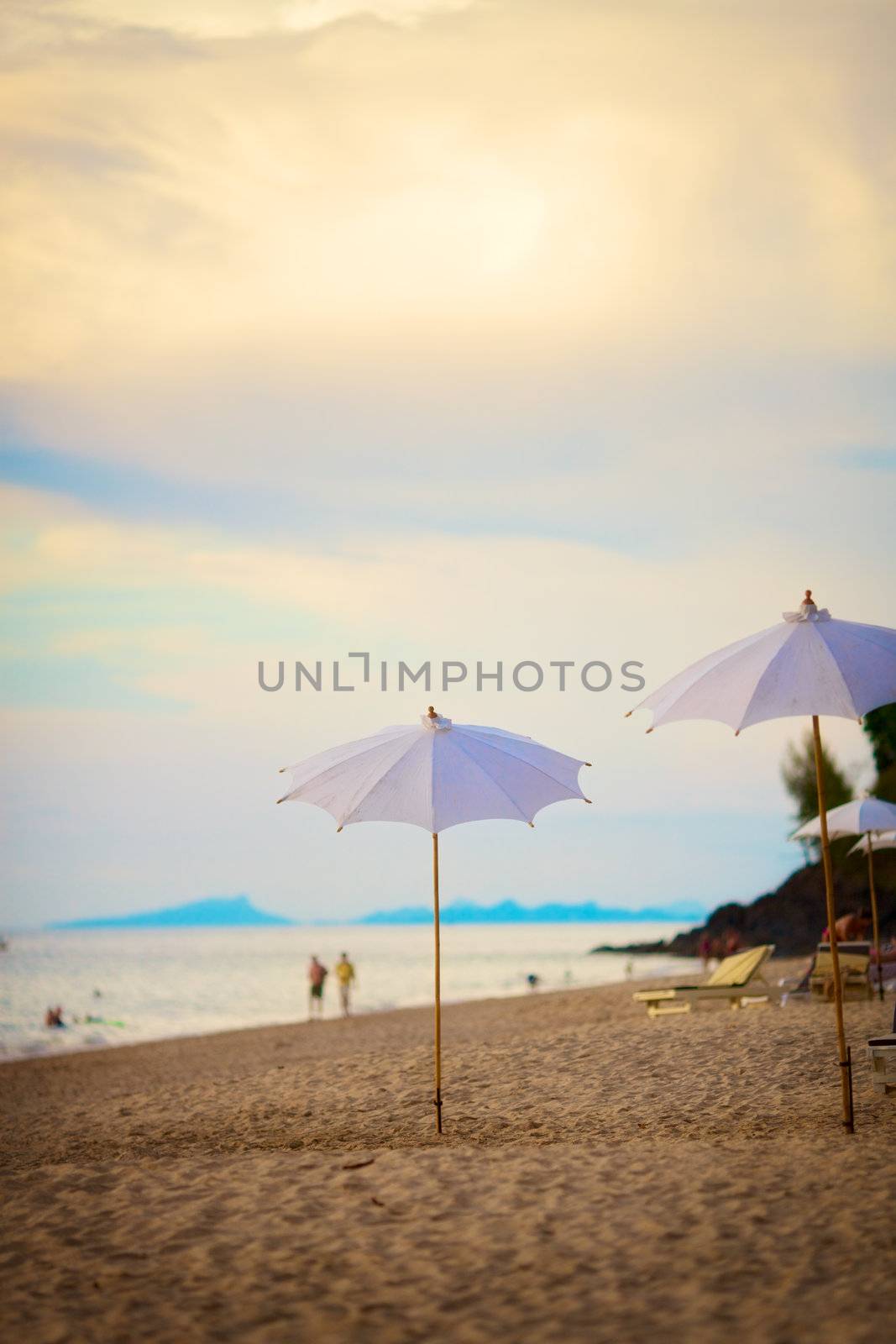 sun umbrellas on beach at evening in Thailand