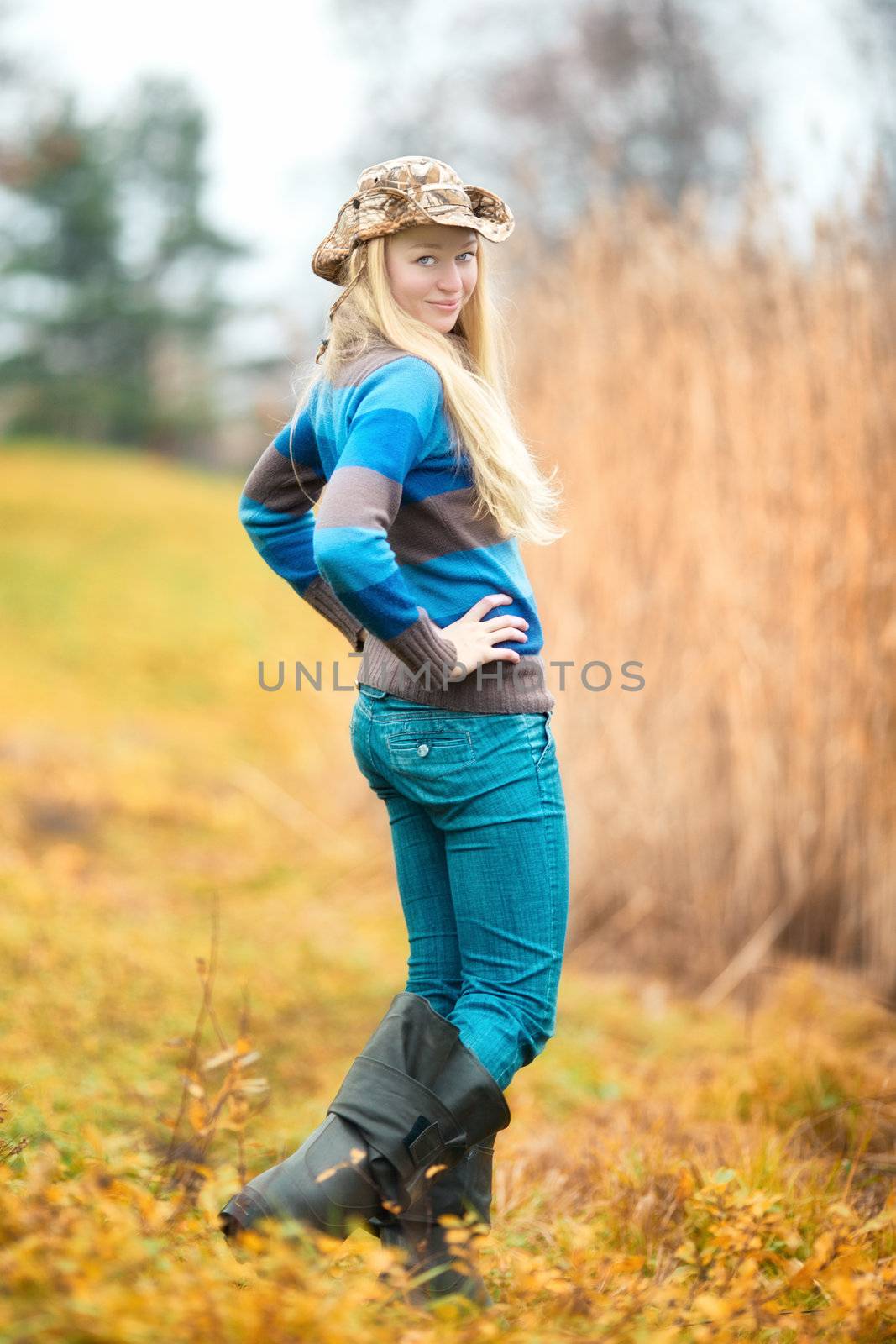 beautiful blond girl in fishing clothing at autumn
