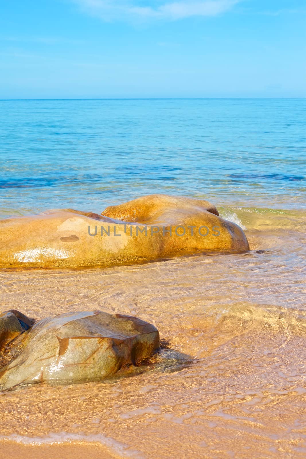 transparent sea with big stone at sunny day