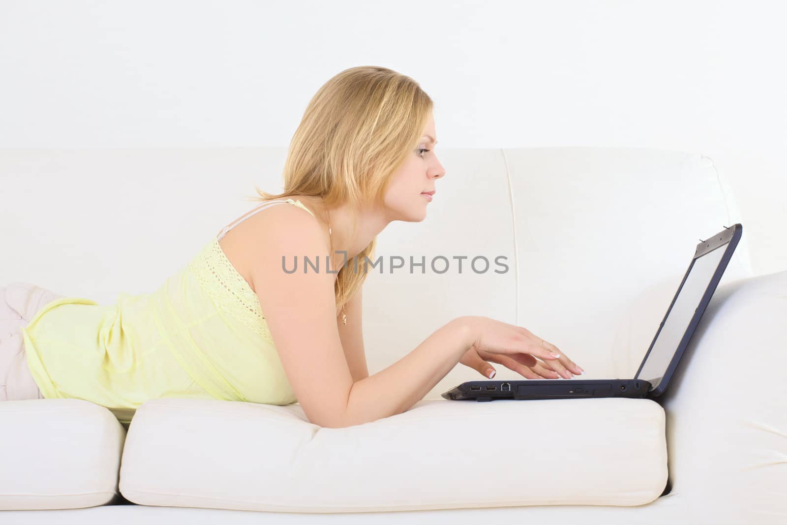 charming woman lying on a sofa with laptop