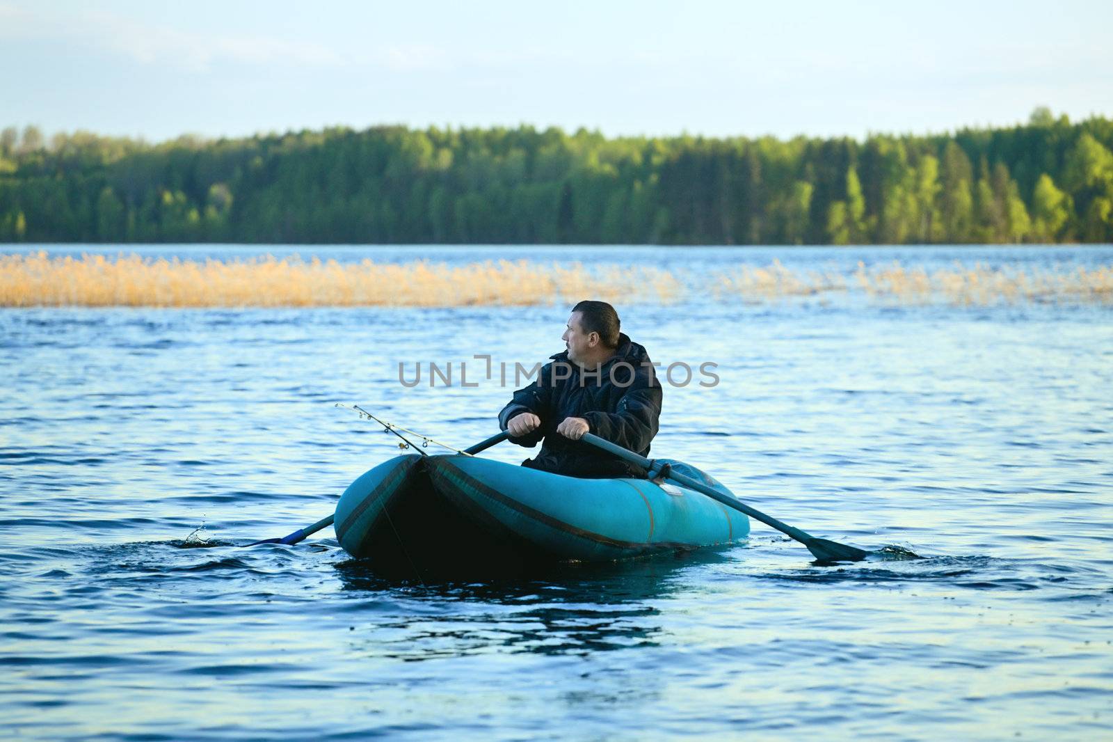 fisherman in rubber boat on a lake