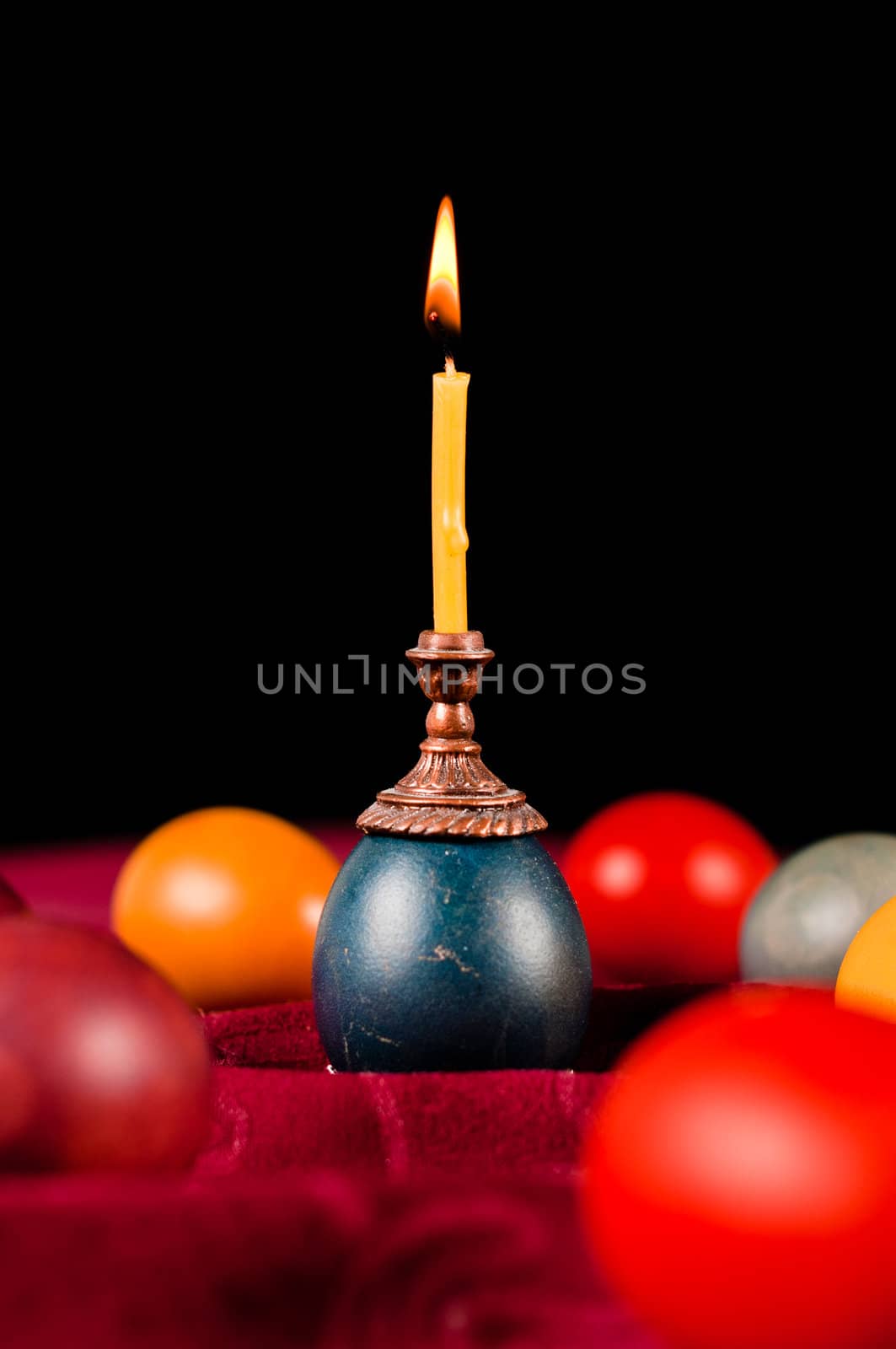 Candle standing on easter egg by dmitryelagin