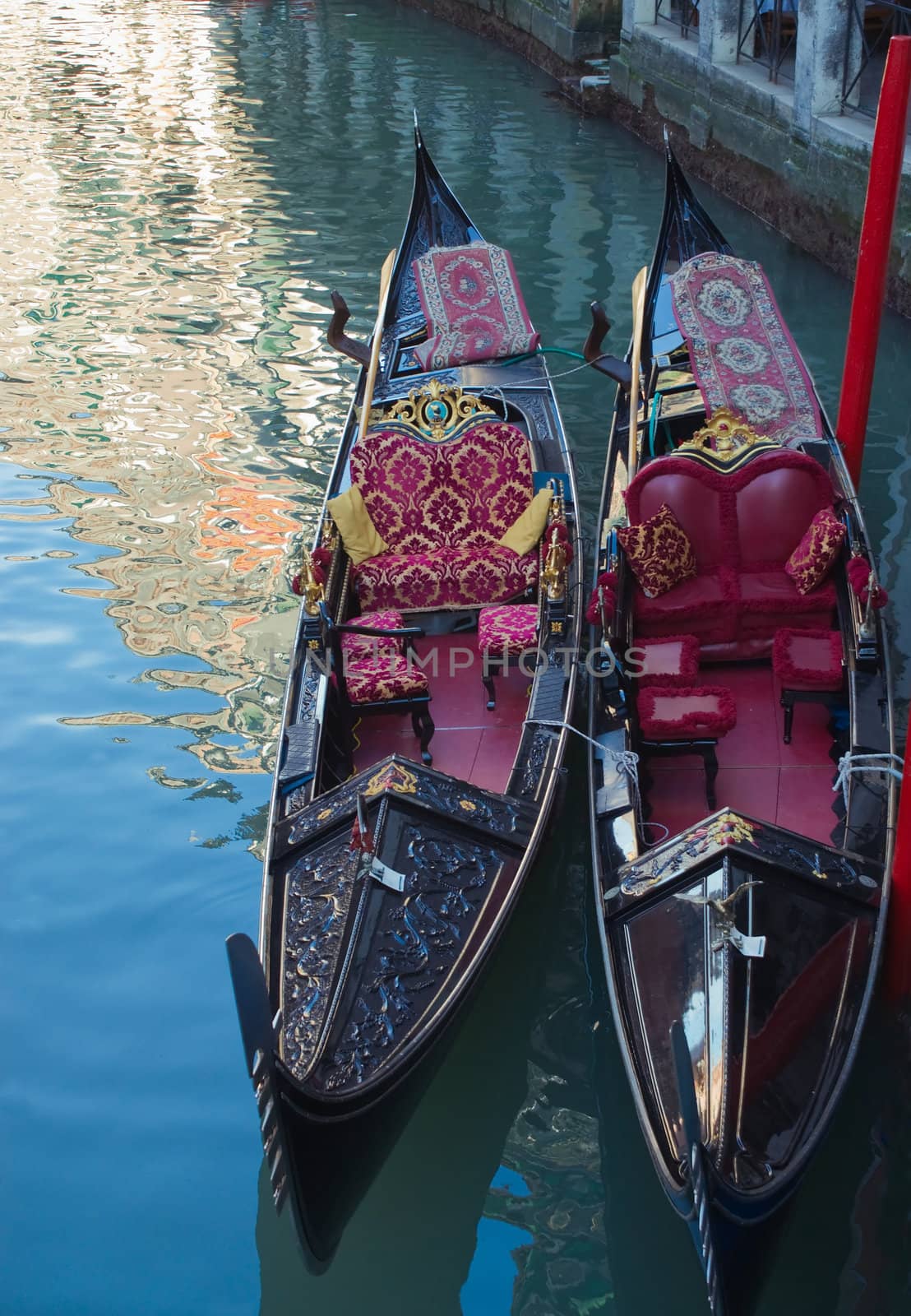 Two gondolas on the canal in Venice, and the reflections