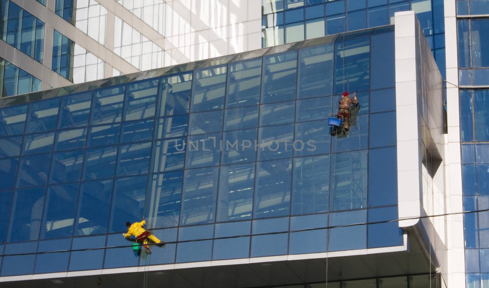 Service of washing windows work on the walls of business center