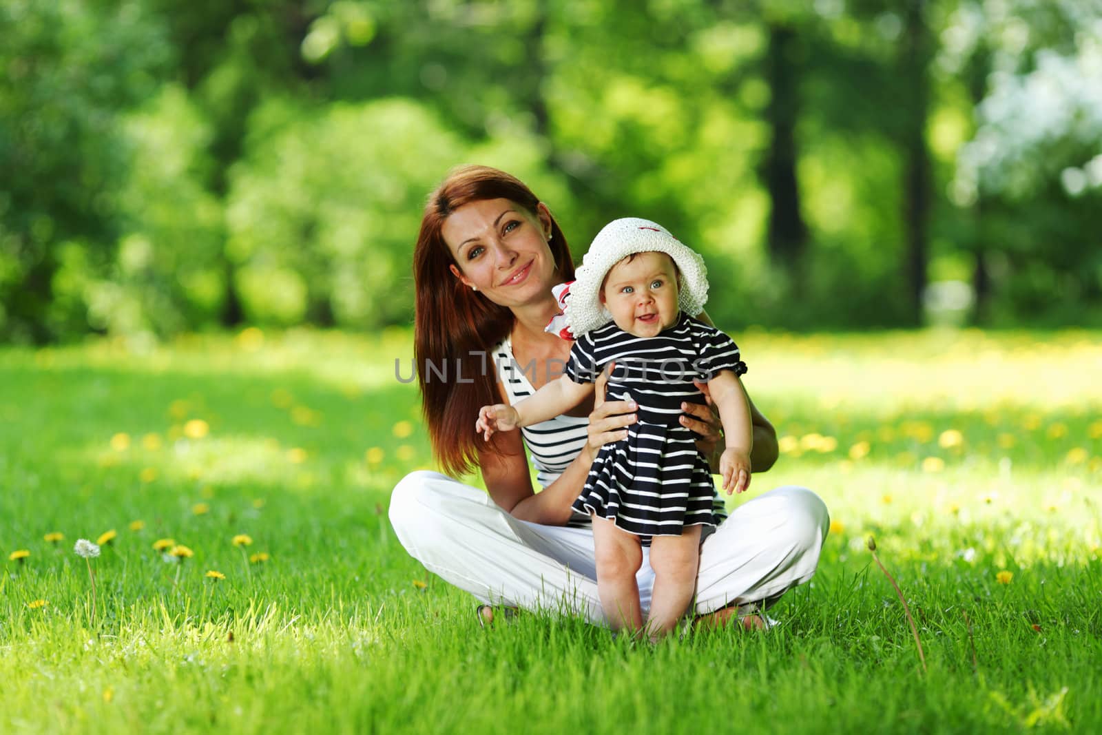 Happy mother and daughter on the green grass