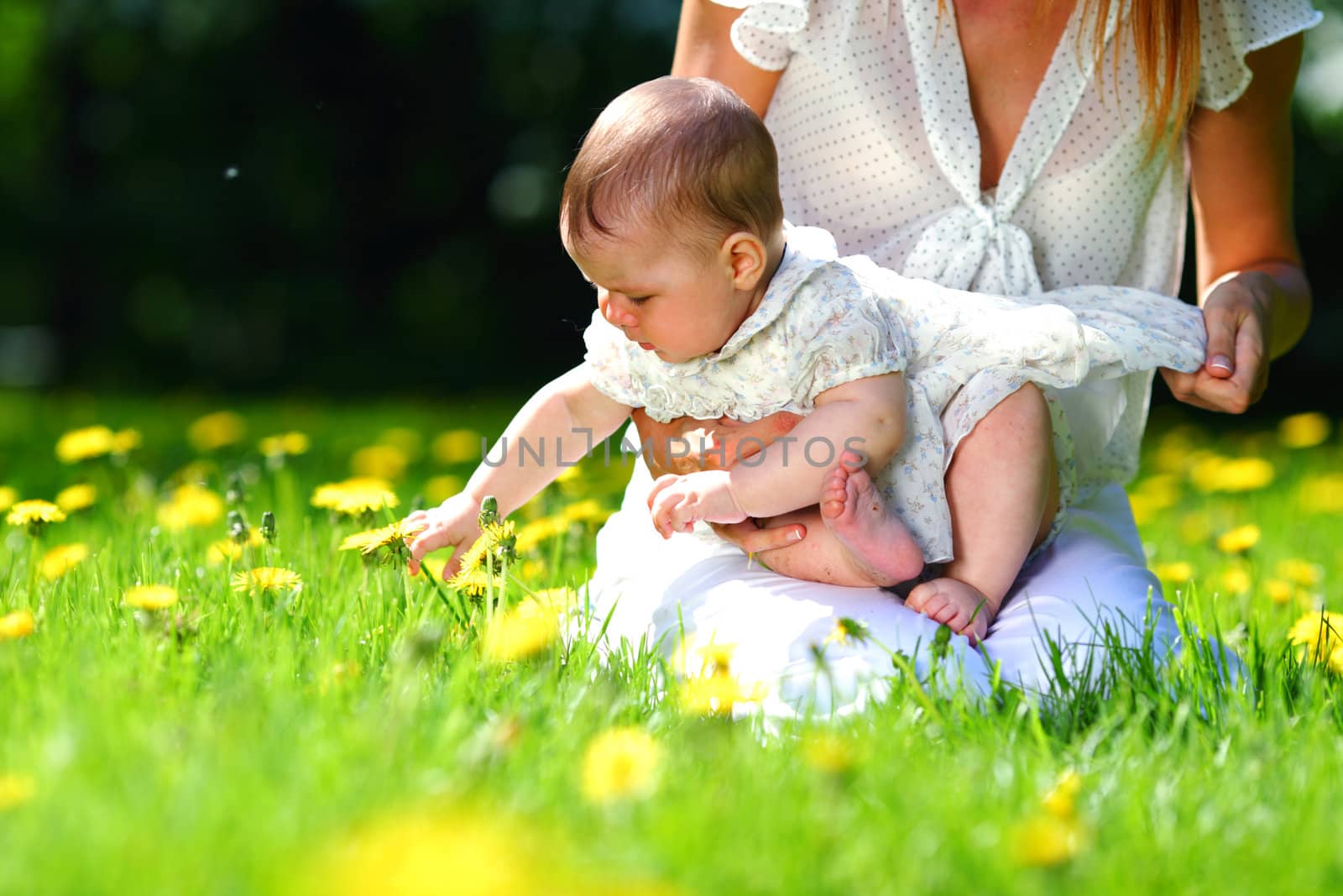 Happy mother and daughter on the green grass