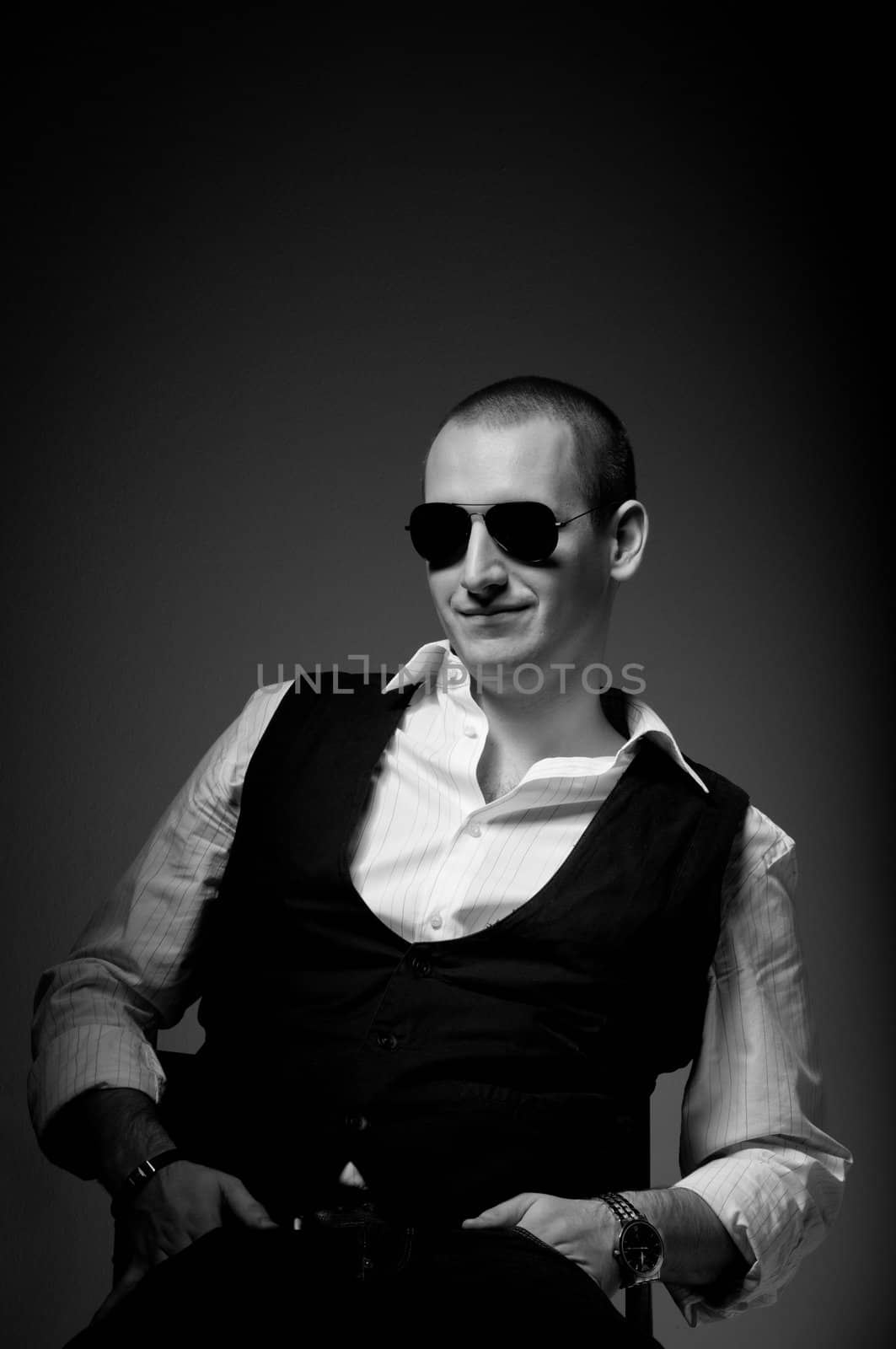 Portrait of a young man wearing sunglasses in black and white