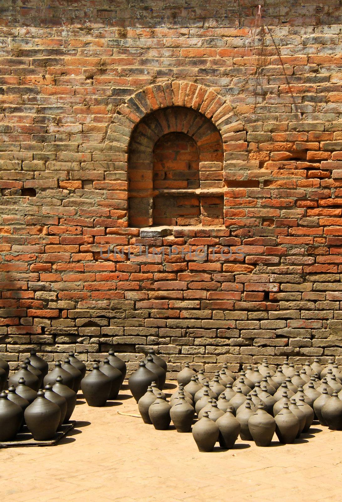 Many clay vases kept for drying with brick wall  by nuchylee